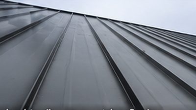 Charcoal standing seam metal roof panels with concealed seams on a Minnesota home
